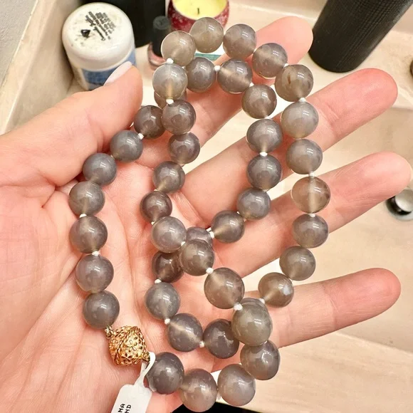 Saks fifth Avenue moon stone hand strung. New in duster. 14k gold plated clasp